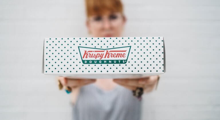 Krispy Kreme donuts box held by woman